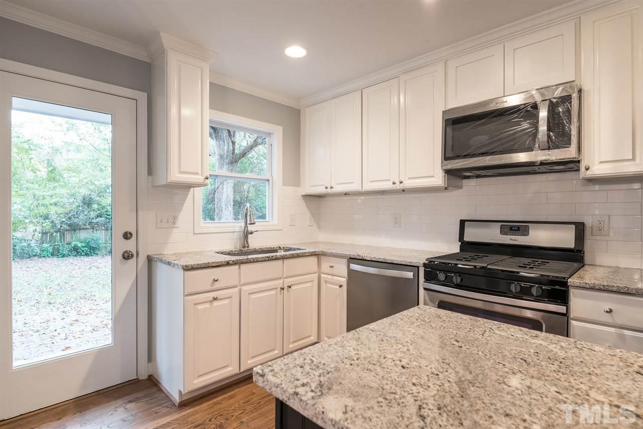 2408 Milburnie Road Raleigh, NC 27610 - Photo 11 of 25 a kitchen with stainless steel appliances granite countertop a stove top oven a sink dishwasher and microwave oven with cabinets