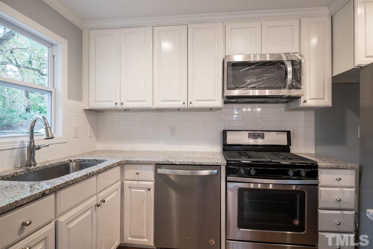2408 Milburnie Road Raleigh, NC 27610 - Photo 12 of 25 a kitchen with granite countertop cabinets stainless steel appliances and a sink