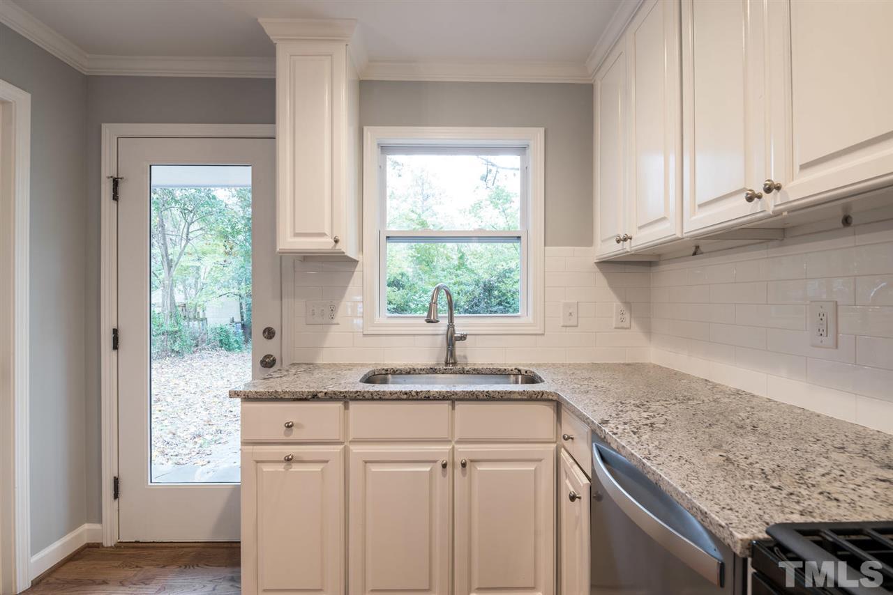 2408 Milburnie Road Raleigh, NC 27610 - Photo 13 of 25 a kitchen with granite countertop white cabinets and a window