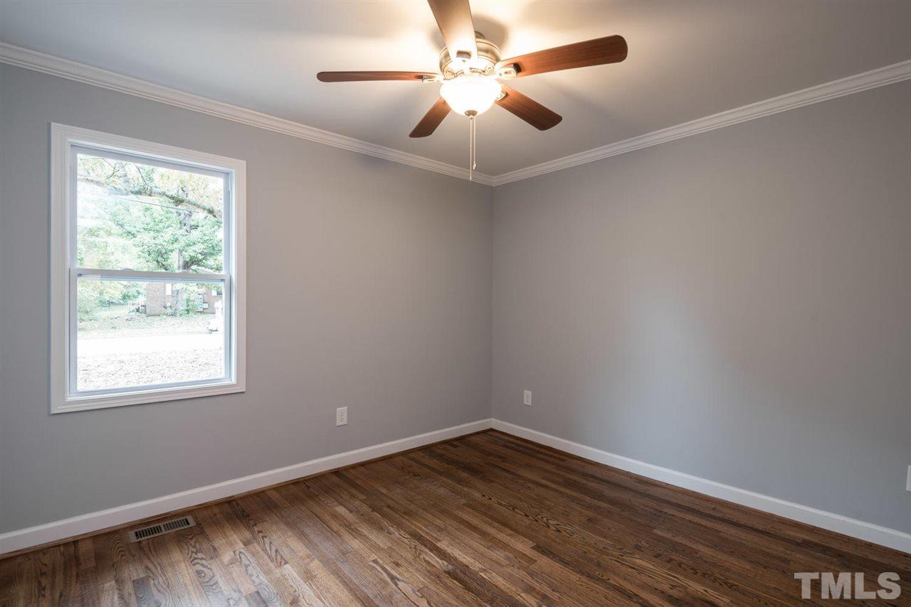 2408 Milburnie Road Raleigh, NC 27610 - Photo 16 of 25 a view of an empty room with wooden floor and a window