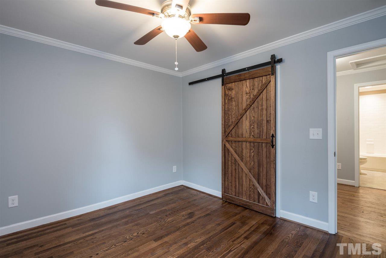 2408 Milburnie Road Raleigh, NC 27610 - Photo 17 of 25 an empty room with wooden floor fan and windows