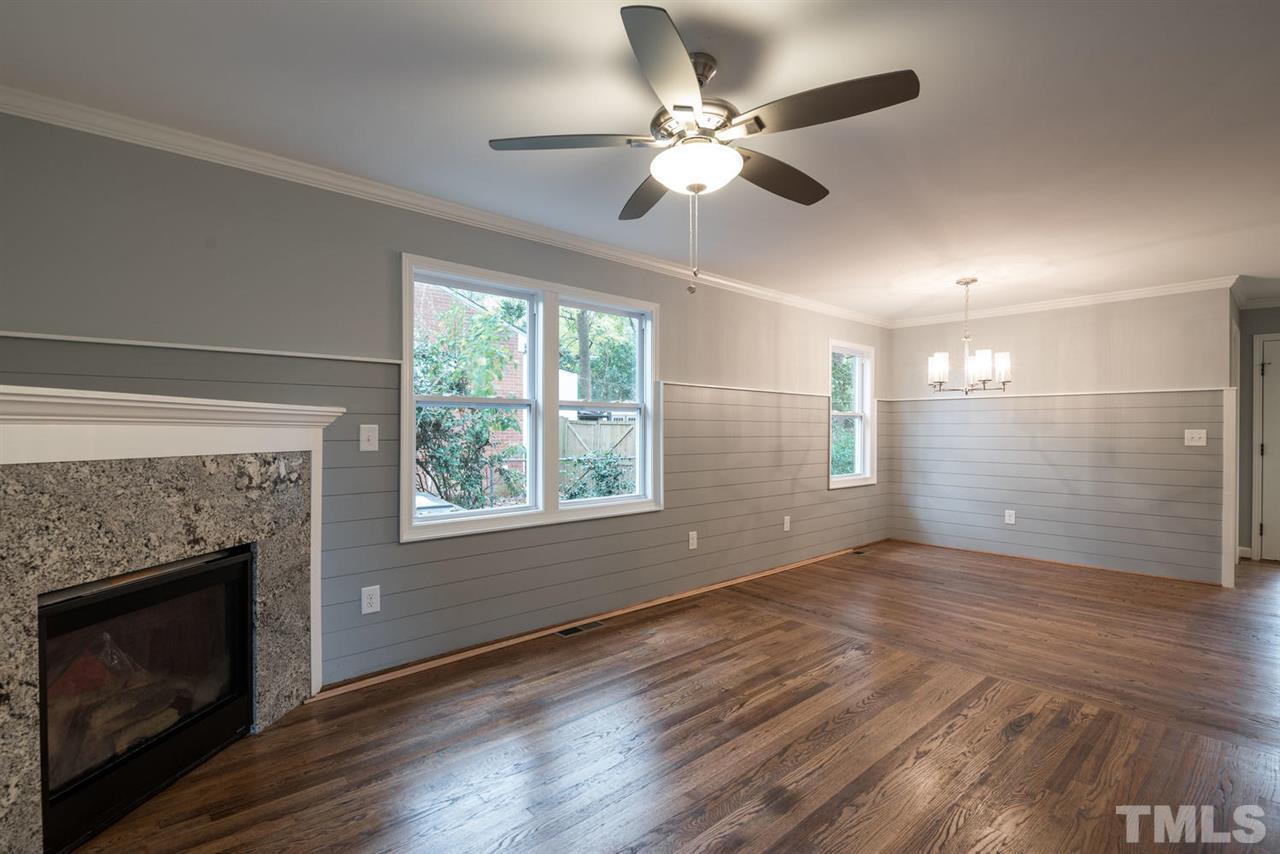 2408 Milburnie Road Raleigh, NC 27610 - Photo 5 of 25 a view of an empty room with wooden floor and a fireplace