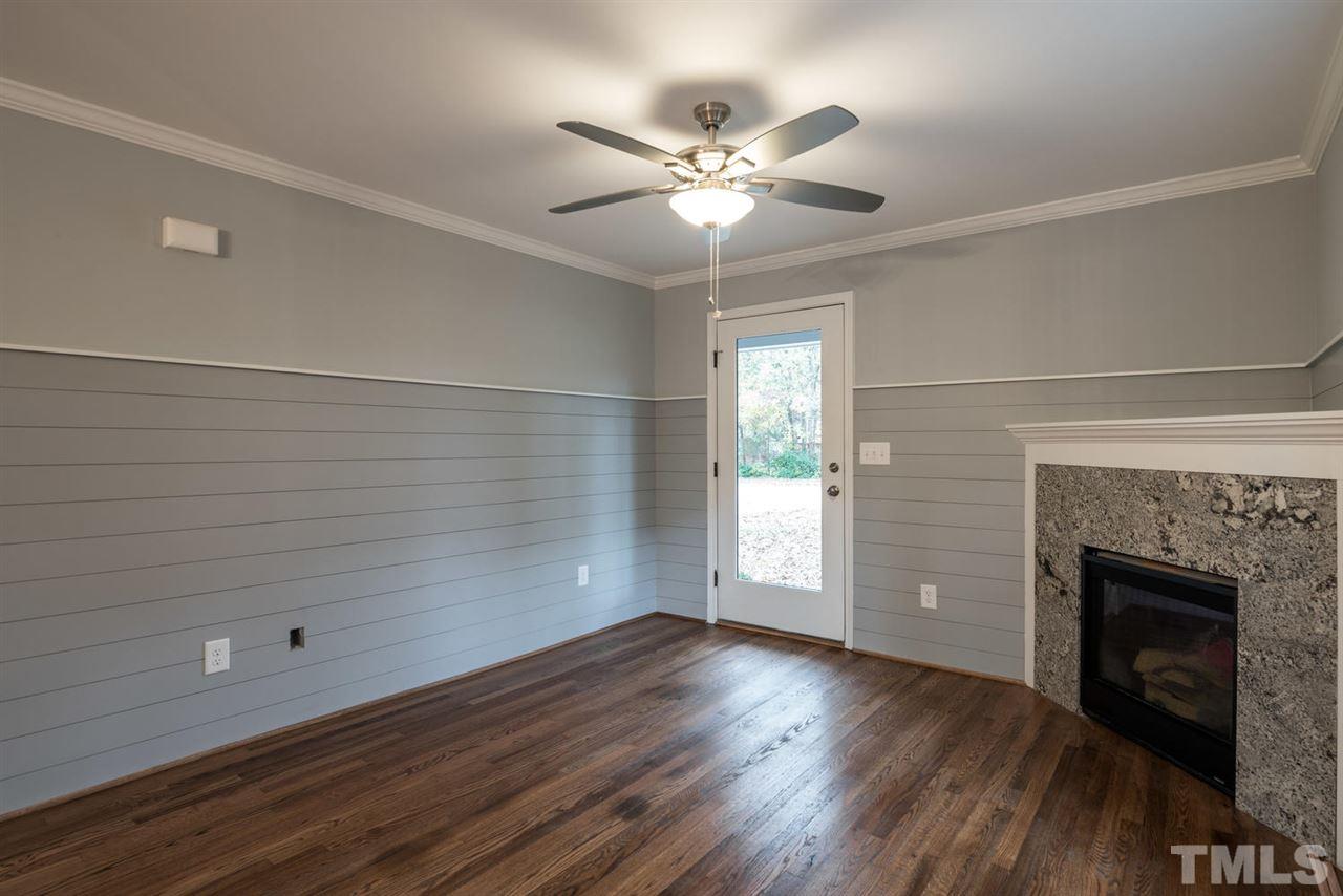 2408 Milburnie Road Raleigh, NC 27610 - Photo 7 of 25 a view of an empty room with wooden floor and a window