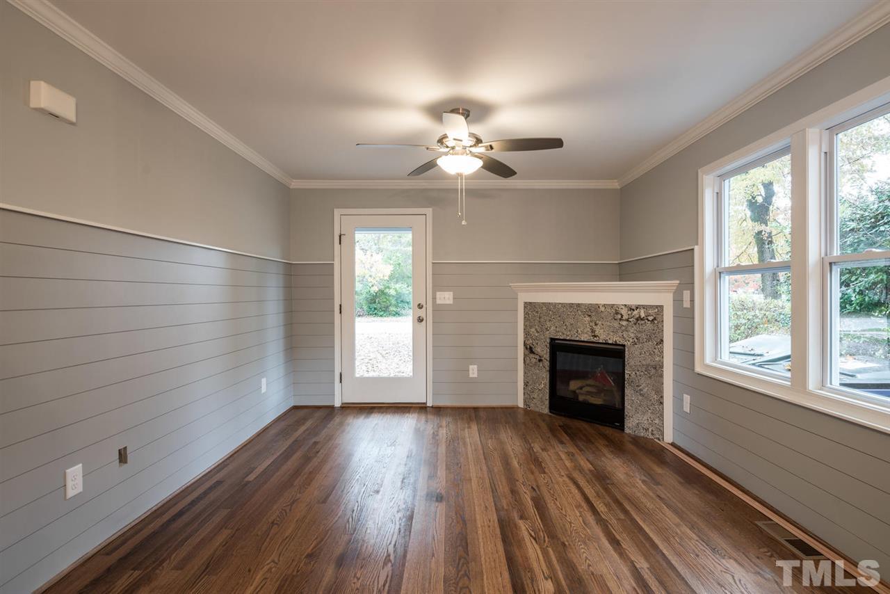 2408 Milburnie Road Raleigh, NC 27610 - Photo 8 of 25 wooden floor fireplace and windows in an empty room