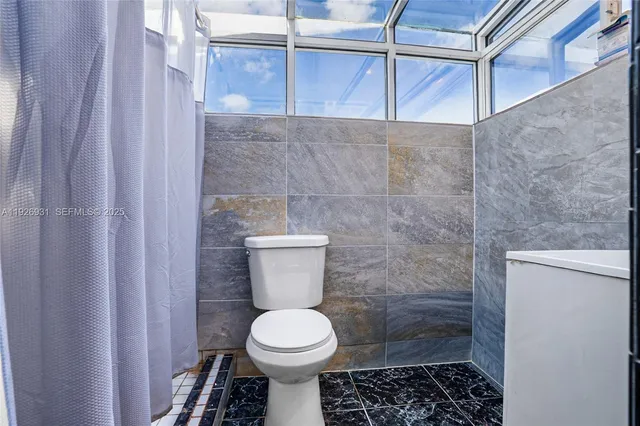 a bathroom with a toilet and a shower
