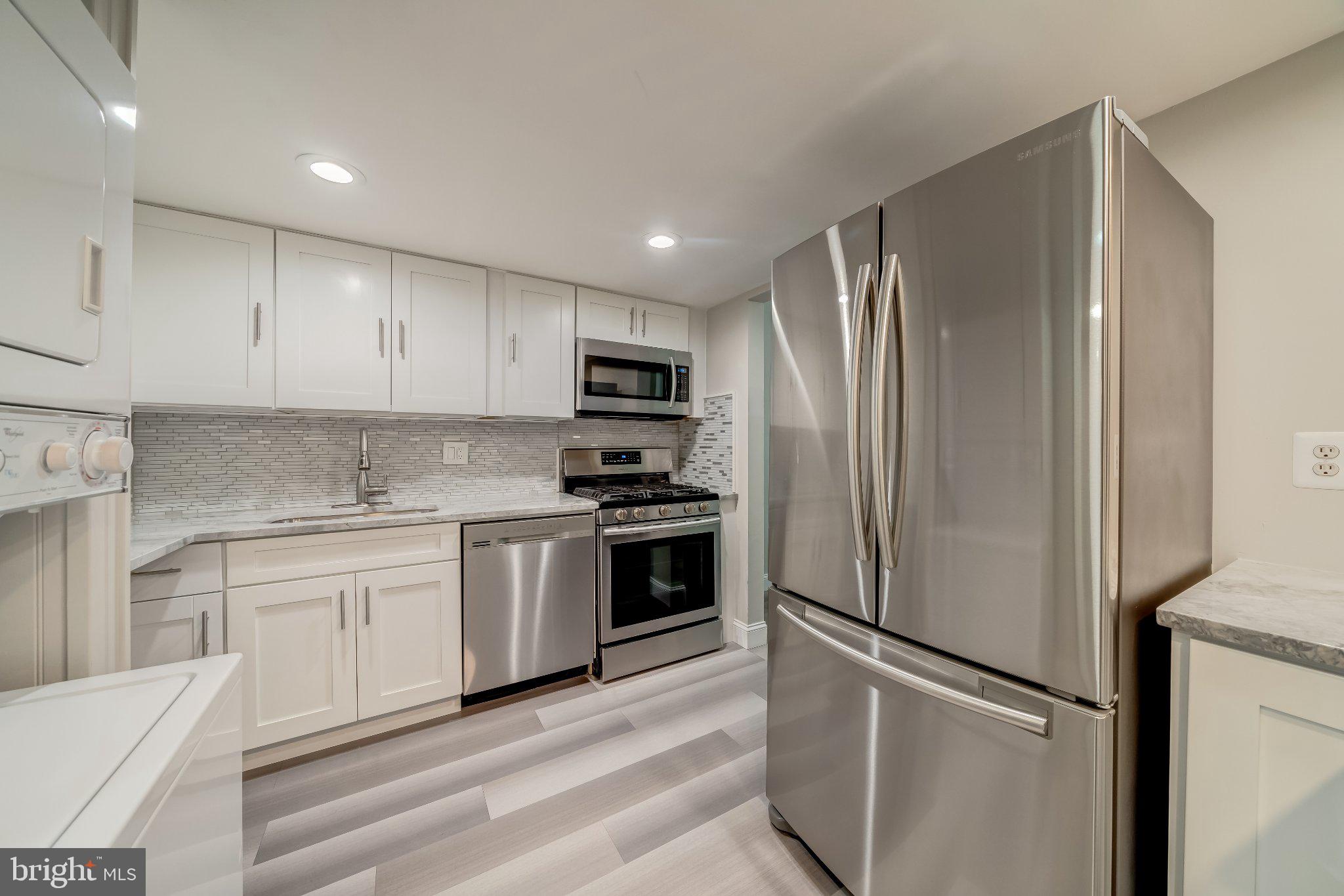 1429 Northgate Square, Unit 2A Reston, VA 20190 - Photo 12 of 25 a kitchen with a refrigerator stainless steel appliances wooden floor and cabinets