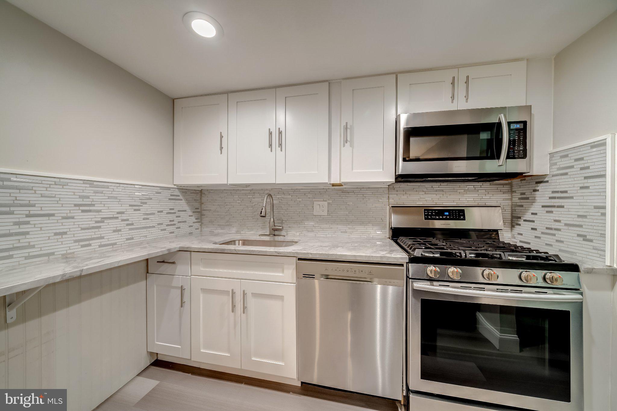 1429 Northgate Square, Unit 2A Reston, VA 20190 - Photo 13 of 25 a kitchen with cabinets stainless steel appliances a sink and a stove