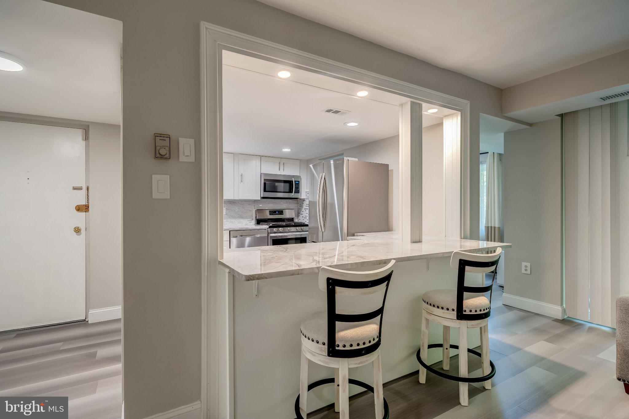1429 Northgate Square, Unit 2A Reston, VA 20190 - Photo 10 of 25 a kitchen with stainless steel appliances kitchen island granite countertop a sink and cabinets