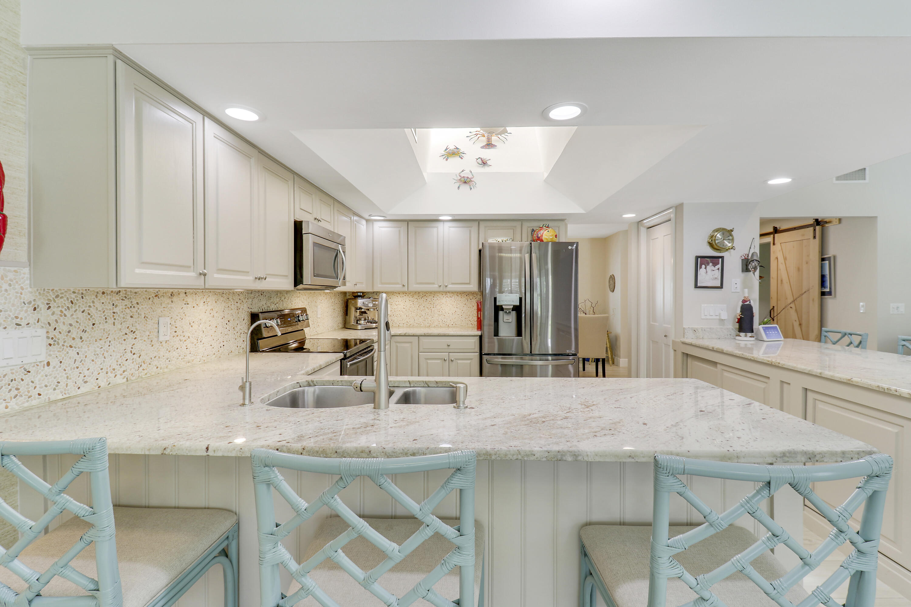 6372 North 197th Place Jupiter, FL 33458 - Photo 18 of 77 a kitchen with stainless steel appliances granite countertop a kitchen island and chairs in it
