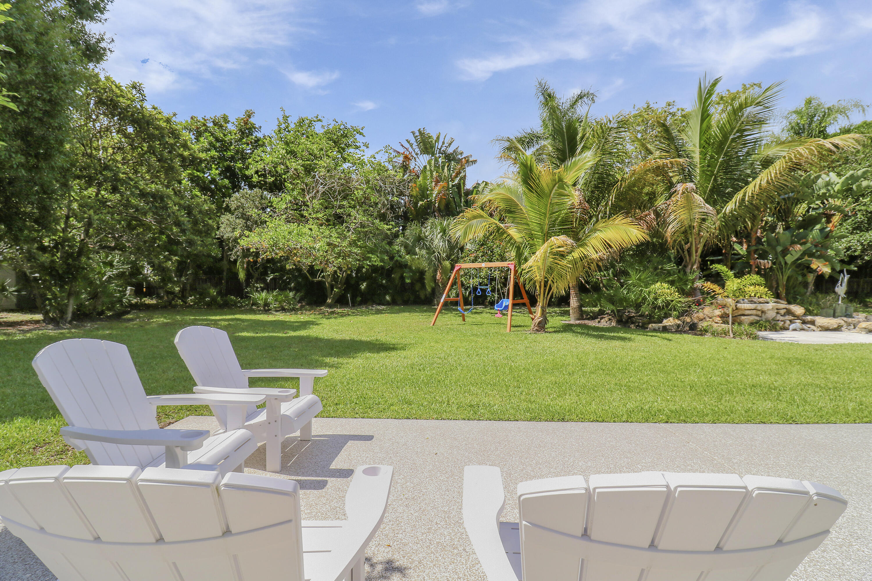 6372 North 197th Place Jupiter, FL 33458 - Photo 33 of 77 a backyard of a house with lots of green space and fountain