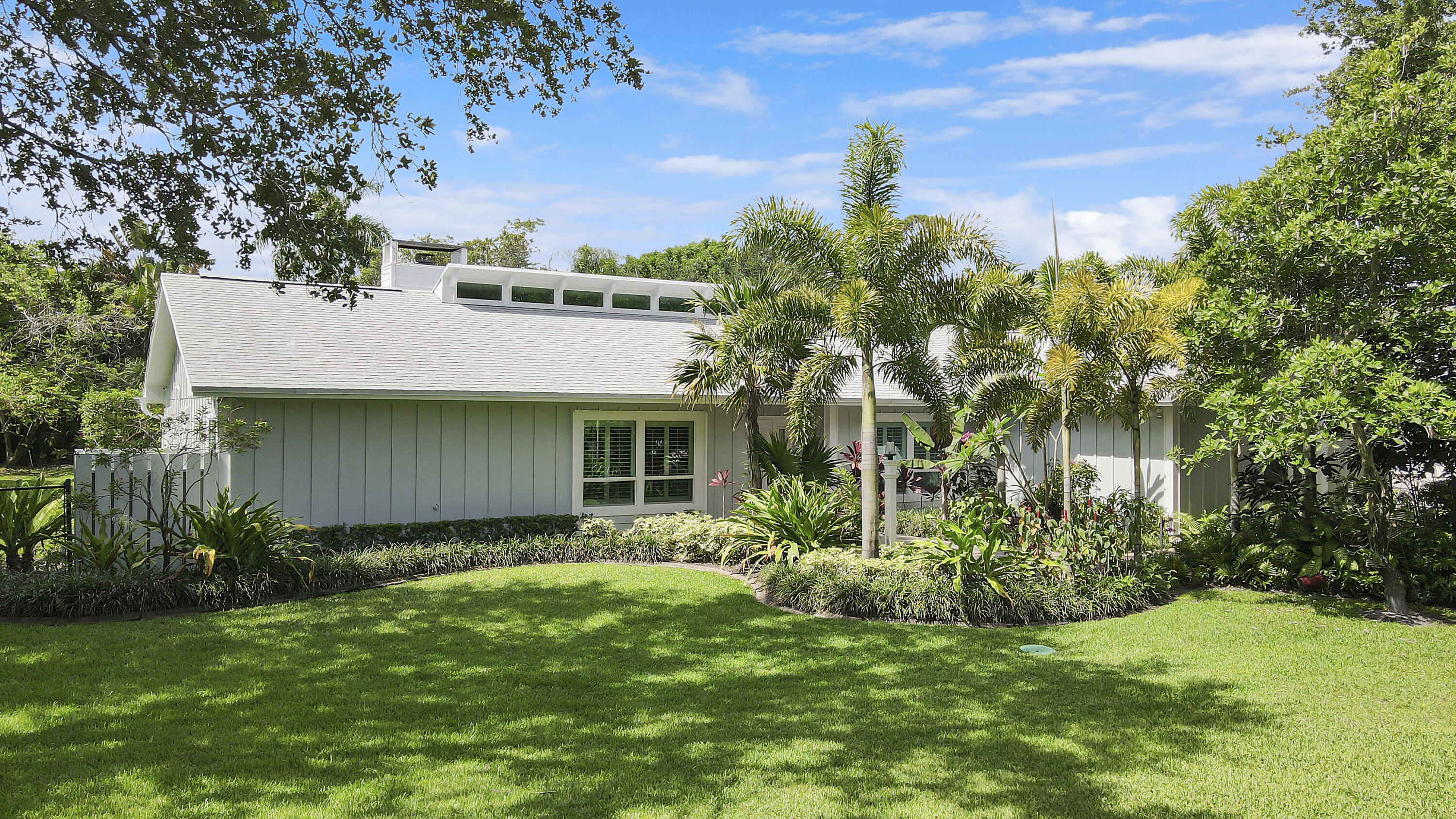 6372 North 197th Place Jupiter, FL 33458 - Photo 61 of 77 a view of a white house next to a yard with plants and trees