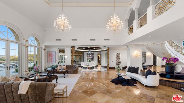 a living room with lots of furniture and chandelier