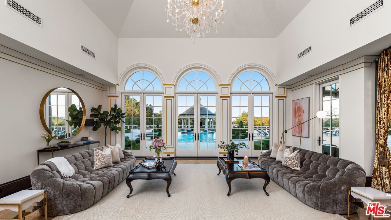 25220 Walker Road Hidden Hills, CA 91302 - Photo 5 of 29 a living room with furniture a large window and a chandelier