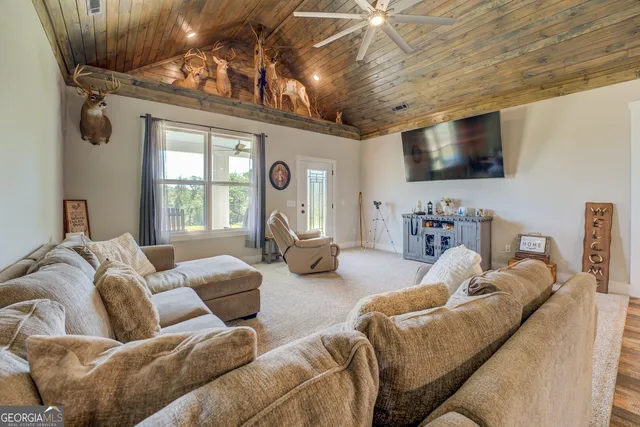a bedroom with a bed and a flat tv screen on dresser