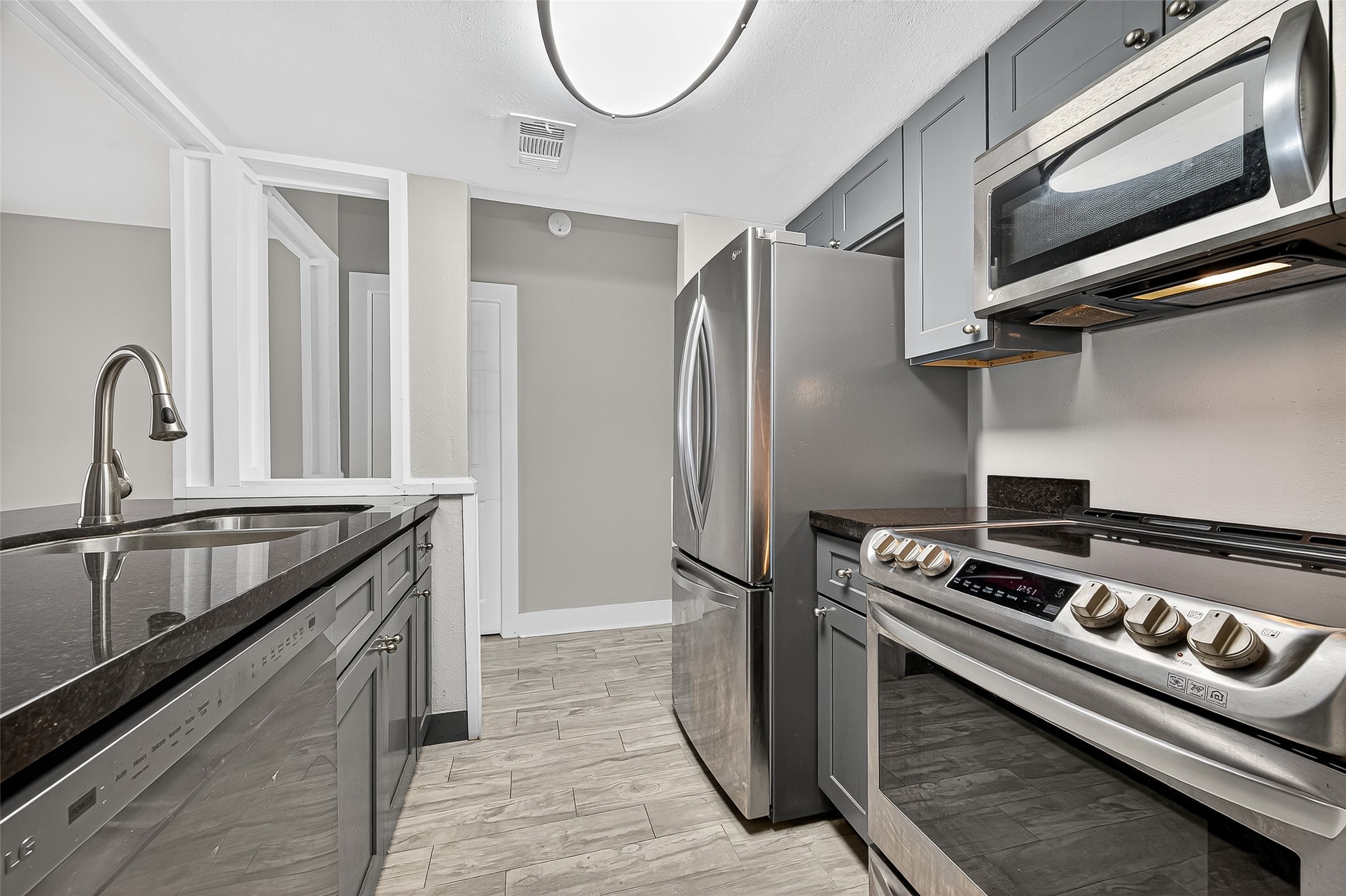 a kitchen with stainless steel appliances granite countertop a stove and a refrigerator