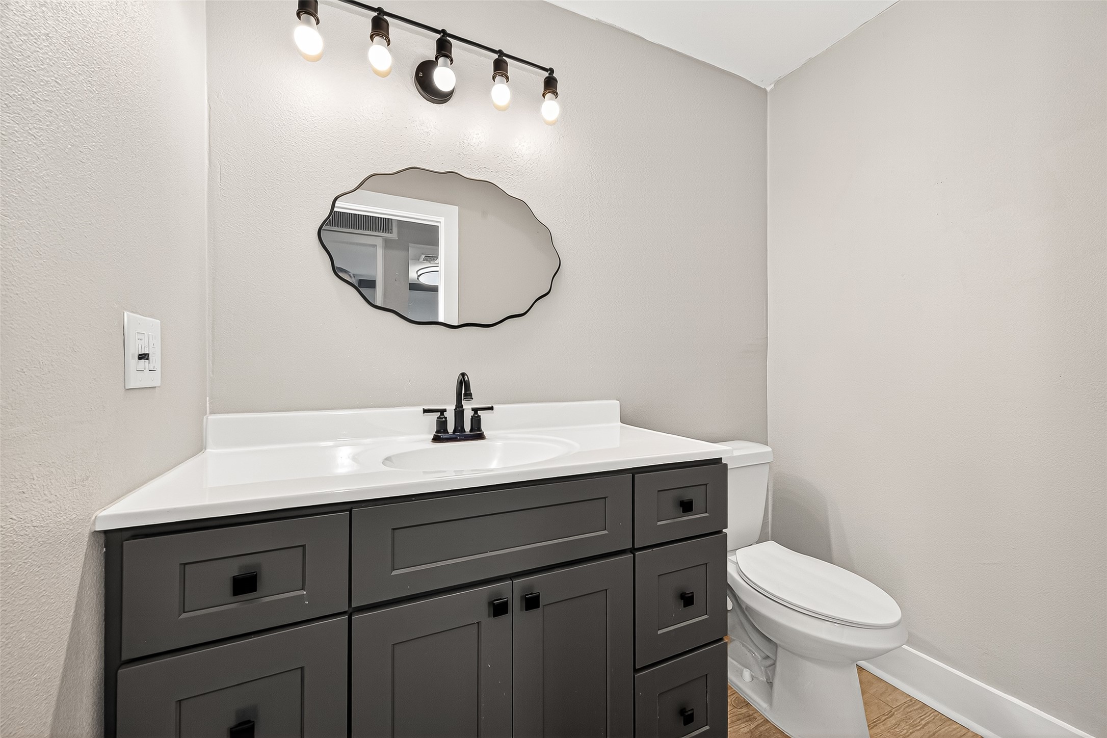 830 Threadneedle Street, Unit 240 Houston, TX 77079 - Photo 10 of 31 a bathroom with a toilet a sink and mirror