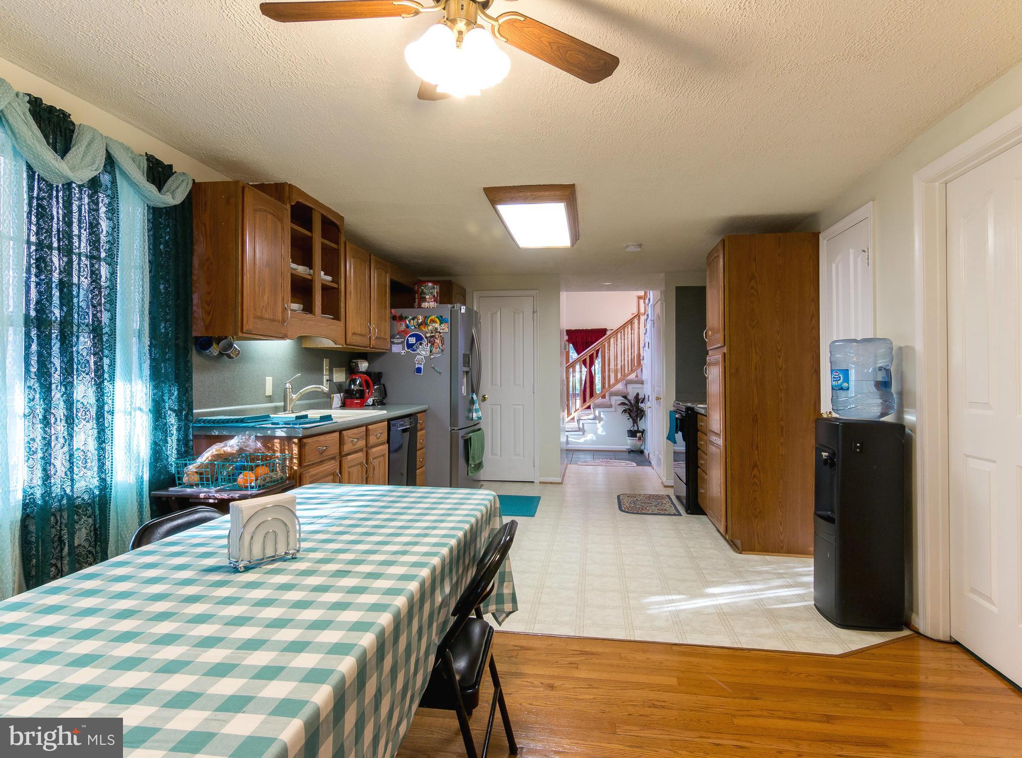 8807 Indian Springs Road Frederick, MD 21702 - Photo 10 of 27 a kitchen with stainless steel appliances wooden floor dining table and chairs