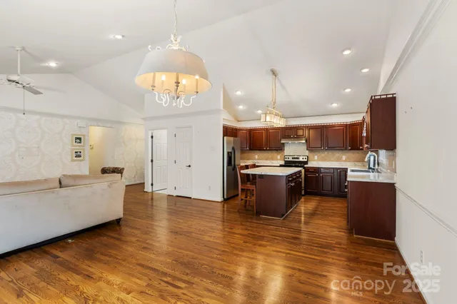 a large kitchen with lots of counter top space a sink stainless steel appliances and cabinets