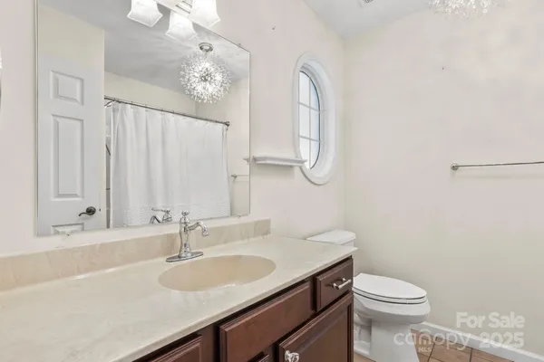 a bathroom with a granite countertop sink a toilet and a mirror