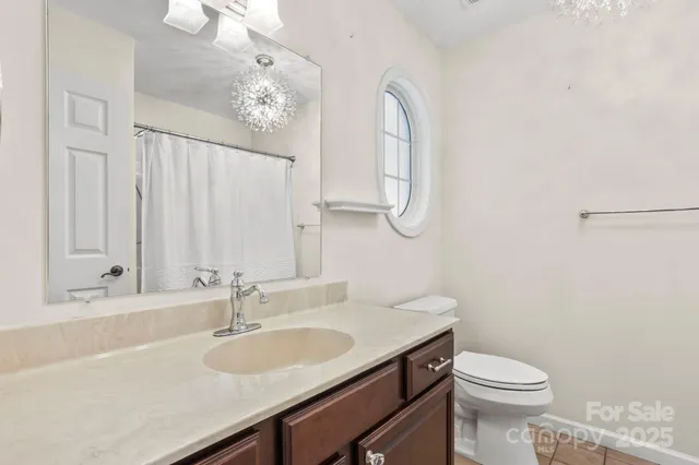 a bathroom with a granite countertop sink a toilet and a mirror