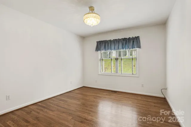 an empty room with wooden floor and a window