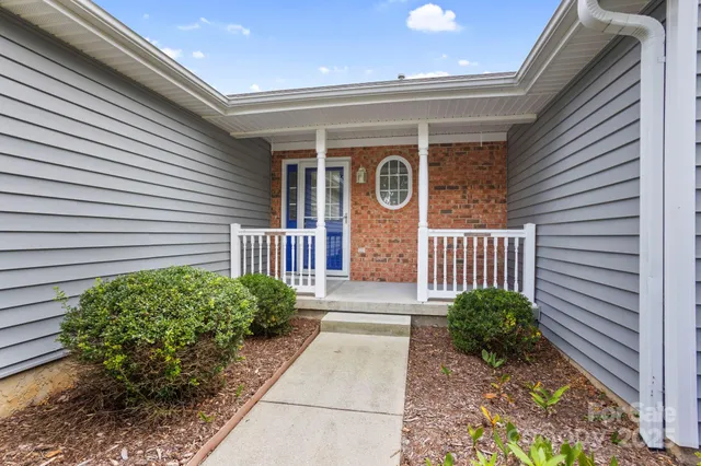 a view of a pathway of a house with a flower garden