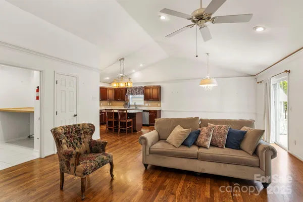 a living room with furniture a wooden floor and a chandelier