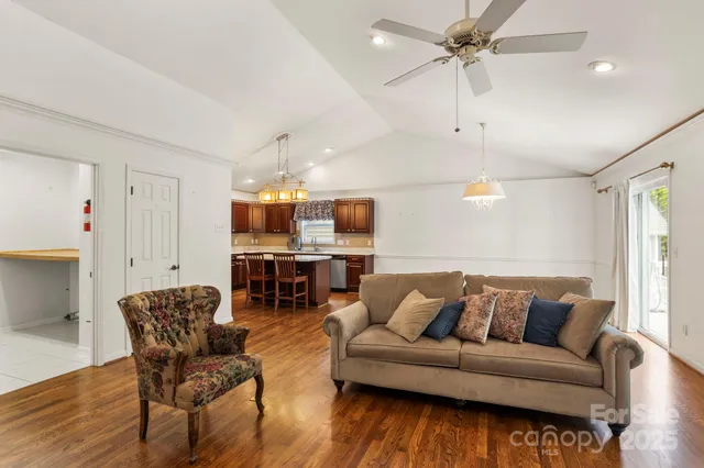 a living room with furniture a wooden floor and a chandelier