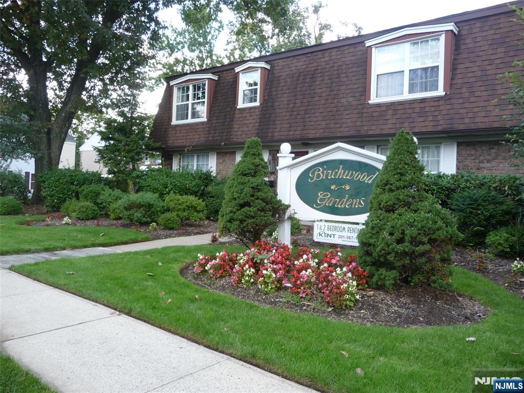 a front view of a house with a garden and plants