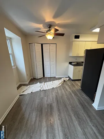 a view of a kitchen with wooden floor and a ceiling fan