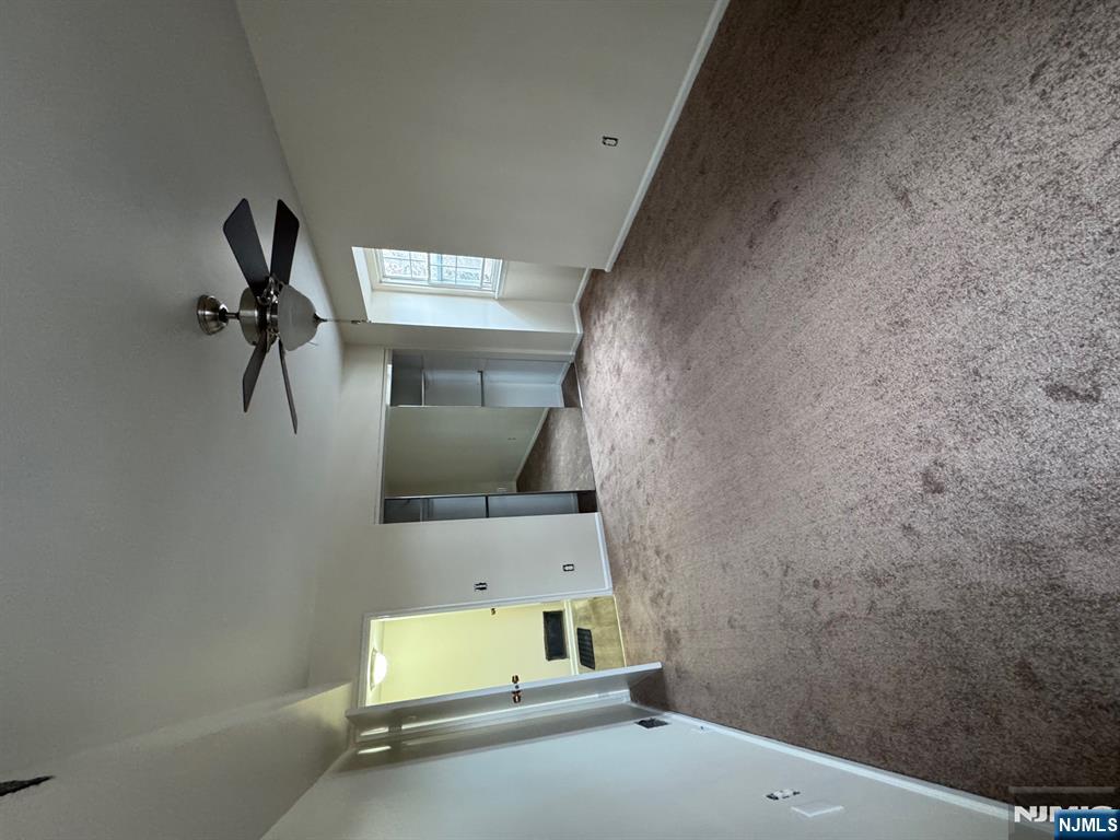 360 Knickerbocker Road, Unit 24 Dumont, NJ 07628 - Photo 5 of 8 en empty room with windows and a ceiling fan