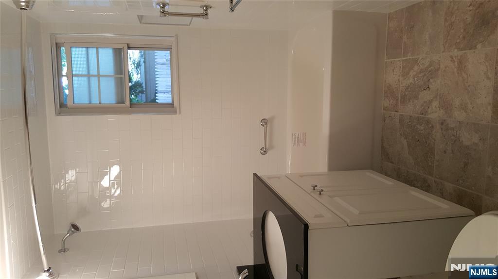 360 Knickerbocker Road, Unit 24 Dumont, NJ 07628 - Photo 6 of 8 a bathroom with a bathtub a shower and a vanity
