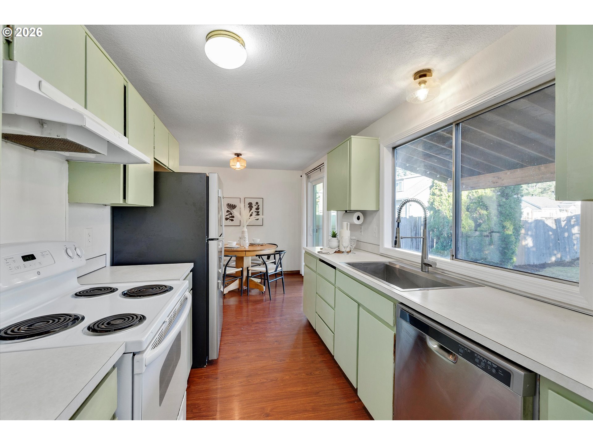 16082 Southwest 93rd Avenue Tigard, OR 97224 - Photo 11 of 35 a kitchen with a sink a stove and a refrigerator