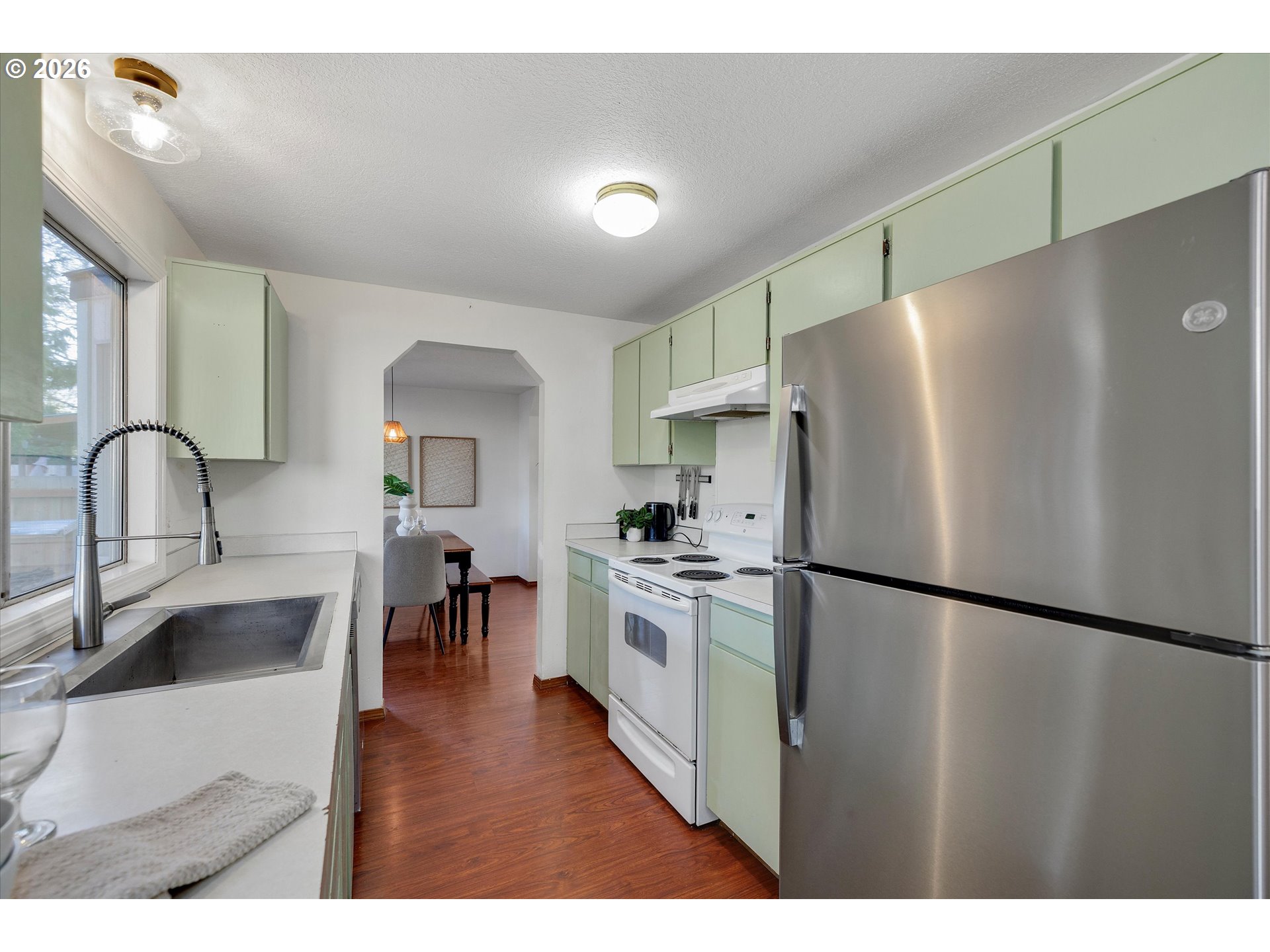 16082 Southwest 93rd Avenue Tigard, OR 97224 - Photo 13 of 35 a kitchen with stainless steel appliances granite countertop a refrigerator a sink a stove and a refrigerator with wooden floor