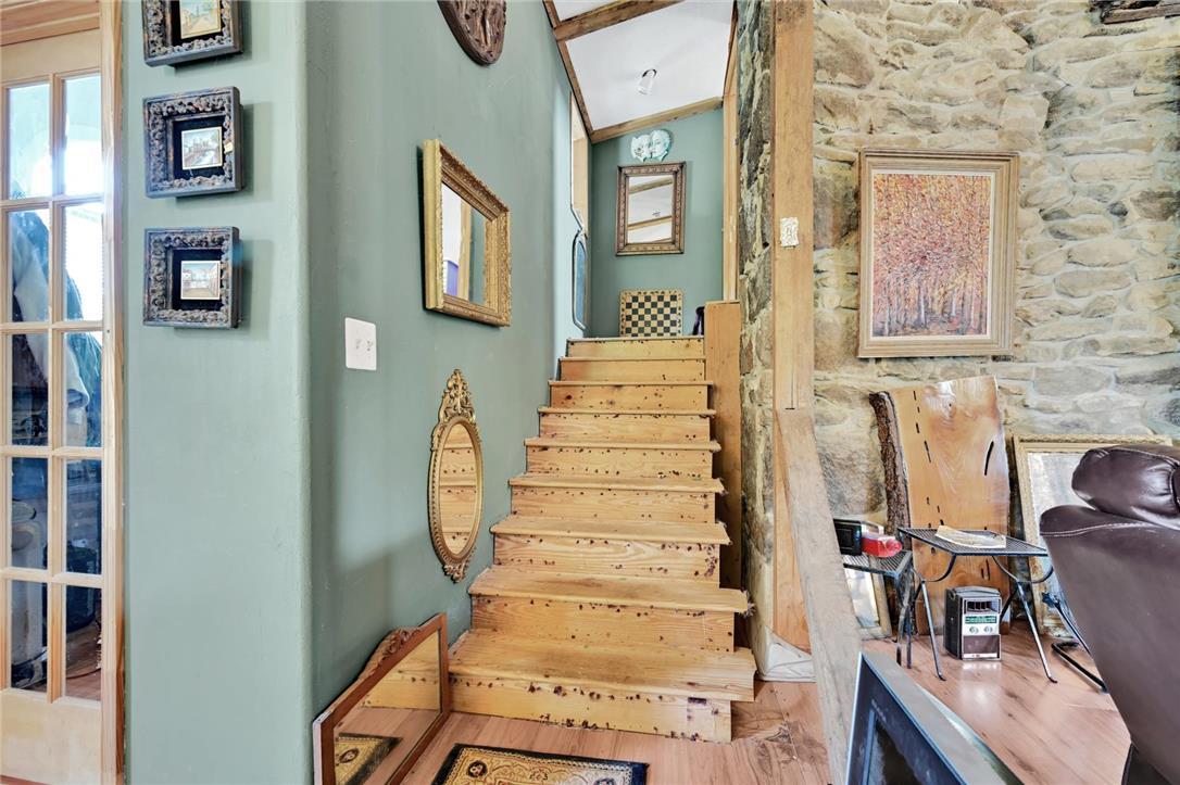 101 Conrad Road Fleetwood, PA 19522 - Photo 5 of 42 Wood stairs lead to a cozy upper level, framed by rustic stone and smooth walls.