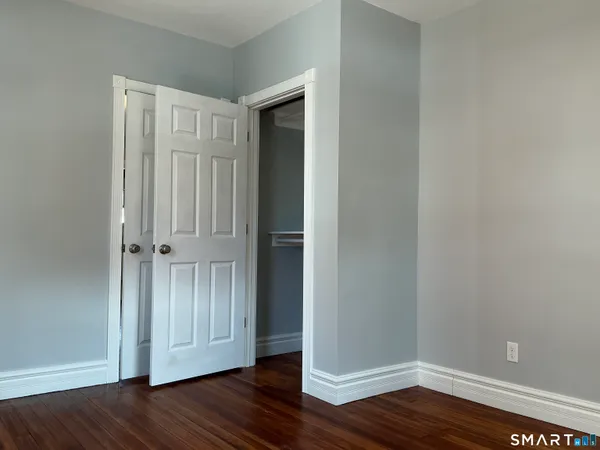 a view of empty room with wooden floor