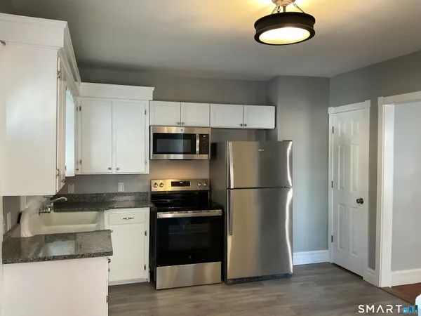 a kitchen with stainless steel appliances granite countertop a refrigerator a stove a sink and a granite counter tops