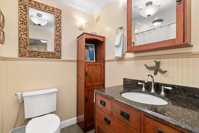 a bathroom with a granite countertop toilet sink and mirror