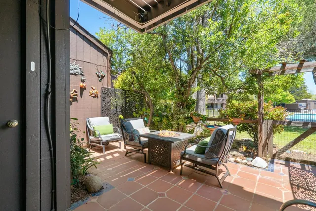 a view of a patio with couple of chairs and potted plants