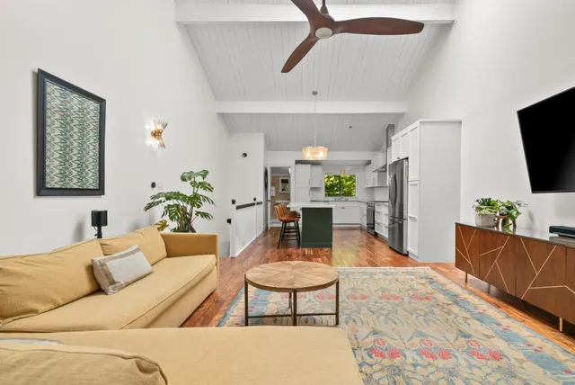 a living room with furniture a flat screen tv and a table