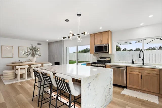 a kitchen with a dining table chairs sink and cabinets