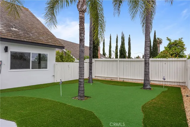 a view of a house with a yard and palm trees