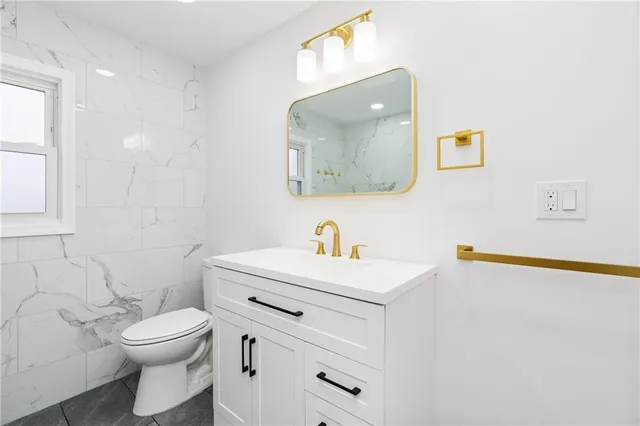 a bathroom with a toilet a sink and mirror