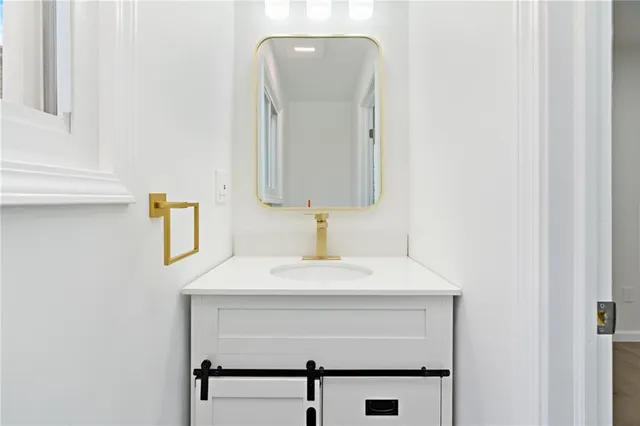 a bathroom with a sink a mirror and vanity