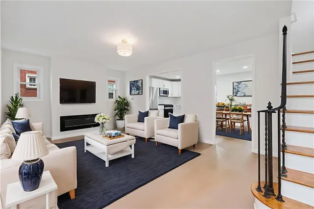 a living room with furniture a flat screen tv and a table