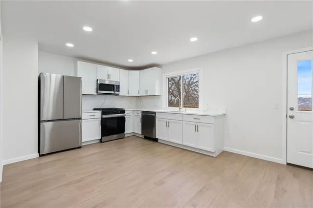a kitchen with white cabinets and white stainless steel appliances