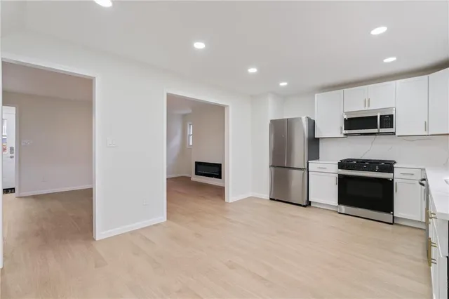 a view of kitchen with stainless steel appliances a refrigerator and a stove top oven