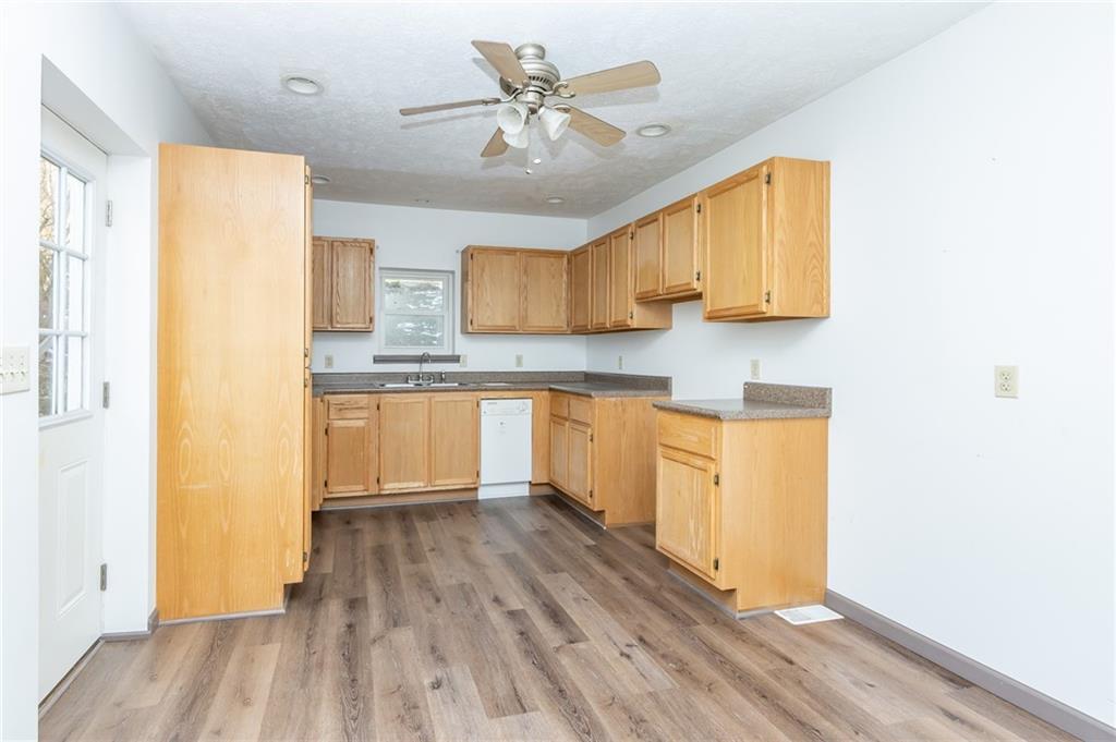400 West Fulton Street Butler, PA 16001 - Photo 13 of 22 a kitchen with stainless steel appliances granite countertop a hardwood floor sink and cabinets