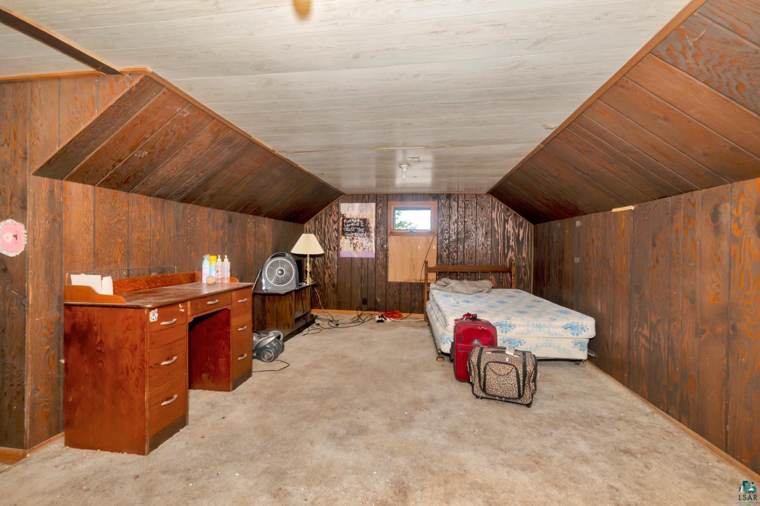5704 Kespohl Road Floodwood, MN 55736 - Photo 18 of 26 Bedroom with light carpet, wooden walls, and lofted ceiling