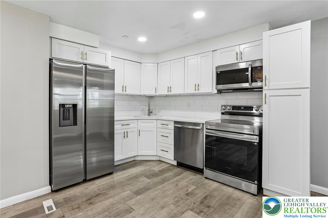 4008 Powell Road Brookhaven, PA 19015 - Photo 11 of 36 A well-appointed kitchen showcasing contemporary white cabinetry and sleek stainless steel appliances.